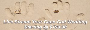 Hand print on sand beach with wedding rings.